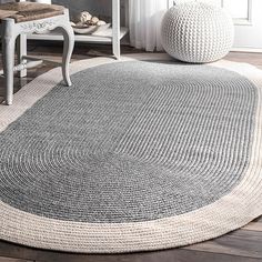 an oval rug in the middle of a room