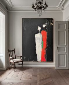 an abstract painting hangs on the wall next to a chair in a room with white walls and wooden floors