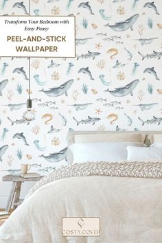 a white bed sitting next to a wallpaper covered in sea animals on it's side