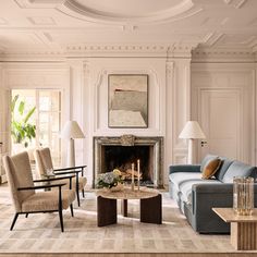 a living room filled with furniture and a fire place under a painting on the wall