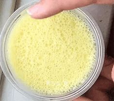 a person holding a bowl with yellow liquid in it