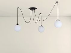 three light fixtures hanging from the ceiling in an empty room