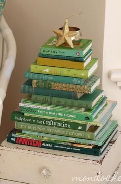 a stack of books sitting on top of a white dresser next to a gold star