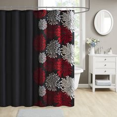 a bathroom with a red and black shower curtain, white toiletries and a mirror