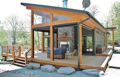 an outdoor living area with a fireplace and covered patio, surrounded by rocks and trees