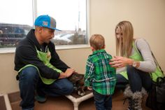 a man and woman sitting next to a small boy with a dog in front of them