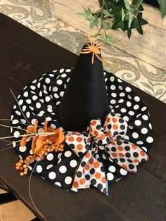 a black and white polka dot hat with orange bows on it sitting on a table