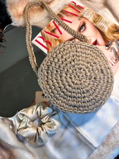 a handbag sitting on top of a bed next to a magazine