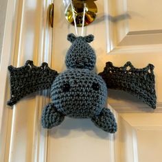 a crocheted bat hanging on the front door