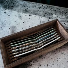 a wooden tray with forks and spoons in it