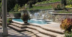 an outdoor swimming pool with steps leading up to it and water running down the side