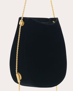 Brought to life in luxe black velvet, the Corvus 0.1 bag shows off a horseshoe-inspired saddle silhouette detailed with the sculptural appeal of rounded corners and a curved base. The goldtone chain strap adjusts with NEOUS' signature pin fastening hardware for elevated versatility. Flap closure Adjustable strap Signature goldtone pin fastening hardware Velvet Outer: 65% viscose, 35% cupro Lining: 100% suede Wipe with soft cloth Made in Italy Measurements Width: 6.69in Height: 7.48in Depth: 2.75 Luxury Formal Bags With Gold Chain, Elegant Formal Bags With Chain Detail, Rectangular Bags With Gold-tone Hardware For Gala, Luxury Formal Shoulder Bag With Gold Chain, Elegant Bags With Gold-tone Hardware For Gala, Rectangular Gala Bag With Gold-tone Hardware, Rectangular Gala Bags With Gold-tone Hardware, Luxury Bags With Chain Strap For Gala, Classic Formal Shoulder Bag With Gold Chain