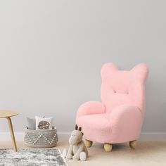 a baby's room with a pink chair and stuffed animal