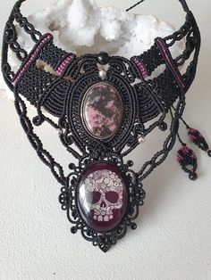 Superb Rhodonite bib necklace and skull cabochon. Real Rhodonite set in silver, the black bead at the top is a Celestial Eye Obsidian and the 2 other black ones on the sides are black tourmaline. Thanks to its sliding clasp, you can wear it to the length you want. This jewel is a Unique piece. I use very fine thread, 1 mm thick (it is therefore rightly called micro-macramé). This thread being waxed, it is very strong and has the advantage of not deforming or fading over time. You can clean your Unique Handmade Skull Necklace, Handmade Adjustable Skull Jewelry, Adjustable Skull Necklace For Festivals, Handmade Gothic Skull Necklace, Unique Black Cabochon Necklace, Types Of Knots, Energy Therapy, Black Skull, Micro Macramé