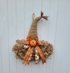 a burlocked scarecrow decoration hanging on the side of a white door