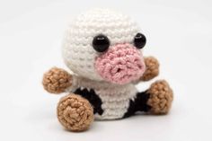 a crocheted stuffed animal sitting on top of a white surface with black eyes