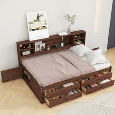 a bed that has drawers underneath it in a room with hardwood floors and white walls