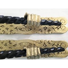 two gold and black bracelets on white background