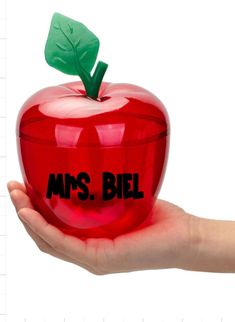 a hand holding an apple with the words mrs biel on it's side