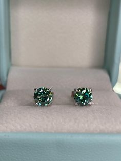 New In!  Beautiful Green Moissanite Stud Earrings in Sterling Silver 925 Weight: 0.8CT+0.8CT  (6mm in diameter each).  Cut: Round Brilliant  Color:Blue-Green, Green  Clarity:VVS Base metal: Sterling Silver 925 Plating: Rhodium  Nickel free, hypoallergenic  Will come with a GRA report (information about the stone) and a Box ready for a gift. *Will pass a diamond tester!  Will be shipped from Los Angeles CA within 1-2 business days ---------------------------------------------- Classic Green Sterling Silver Diamond Earrings, Anniversary Green Diamond Sterling Silver Earrings, Anniversary Green Diamond Earrings In Sterling Silver, Green Sterling Silver Diamond Earrings With Prong Setting, Green Sterling Silver Diamond Earrings For Anniversary, Gift Green Diamond Earrings In Sterling Silver, Green Sterling Silver Diamond Earrings Gift, Green Sterling Silver Diamond Earrings, Green Brilliant Round Cut Earrings