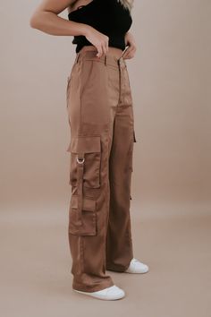 The Silk Cargo Pants in Coco are a luxurious and versatile addition to your wardrobe. These cargo pants offer a blend of comfort and style. The coco color exudes elegance, and the silk material adds a touch of refinement to your look. Silk cargo pants Two back pockets Two side hip pockets Three cargo pockets Button and zipper closure Belt loops Elastic waistband in the back for added comfort Fabric Contents: 100% POLYESTER Inseam: Small 30 in Medium 30.25 in Large 30.50 in Rise: Small 11.25 in M Luxury Wide Leg Brown Cargo Pants, Luxury High-waisted Cargo Pants With Patch Pockets, Luxury Khaki Cargo Style Bottoms, Luxury Wide Leg Cargo Pants For Women, Luxury High-waisted Cargo Pants With Side Pockets, Luxury Fall Cargo Pants With Patch Pockets, Luxury High Rise Cargo Pants With Pockets, Luxury Chic Cargo Pants With Multiple Pockets, Luxury Straight Leg Cargo Pants For Spring