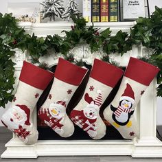 three christmas stockings hanging from a mantel with holly wreaths and snowmen on them