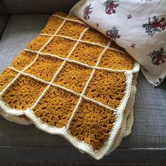 a crocheted blanket sitting on top of a couch