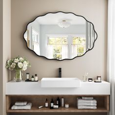 a bathroom with a sink, mirror and flowers on the shelf in front of it