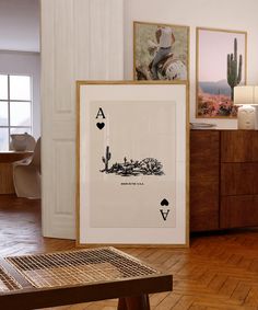 a wooden table topped with framed pictures next to a wall