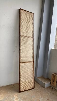 a tall piece of rattan is leaning against the wall next to a step case