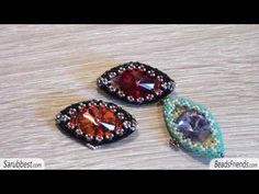 three different colored stones sitting on top of a wooden table with beaded trimmings