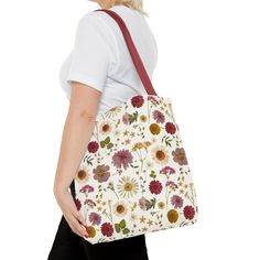 Embrace your free spirit with our stunning Wildflower Tote Bag, a delightful fusion of whimsy and practicality. Crafted with love and care, this tote bag features a vibrant array of bohemian-inspired floral patterns that will instantly transport you to a blooming garden oasis. Each flower and leaf is intricately designed, adding a touch of artistry to your everyday ensemble. Specifications Material: 100% polyester, (handle 100% cotton) Sizes: 13'' x 13'', 16'' x 16'', & 18' 'x 18'' Interior: Non-woven laminate lining White Botanical Tote Bag, Bohemian Bags With Floral Print, Botanical White Tote Bag, Bohemian Bags With Floral Print For Daily Use, White Botanical Style Bag For Spring, Bohemian Flower-shaped Bag For Gifts, White Floral Print Bags As Gifts, Bohemian Everyday Flower Shoulder Bag, White Floral Print Flower-shaped Shoulder Bag