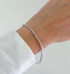 "Shiny And Bright 14K White Gold Moon Cut Ball Bead Bracelet. Diamond Cut Beads That Are Perfect For Layering Or Worn Alone. The Perfect Gift To Give. Jewelry Comes In A Cute Gift Box Ready To Present.  ▪️All Jewelry Is New And Inspected For Quality Assurance.  ▪️Jewelry Is Crafted In Genuine High Quality 14K Gold. ▪️We Do Not Sell Gold Plated.  Product Detail: Metal: 14K White Gold Width: 2.5MM Length: 7\" Inch Closure: Lobster Claw Weight: 3.4 Grams ✨ Feel free To Ask Me Any Questions Or Concerns You May Have ✨ 🌈 Follow Me On Instagram @sarakayjewelry Thank You For Visiting My Shop." Dainty Beaded Rosary Bracelet, Elegant Beaded Chain Bracelet For Everyday, Elegant Everyday Beaded Chain Bracelet, Elegant Beaded Bangle Bracelet With Faceted Beads, Adjustable Beaded Bracelets With Sparkling Stones, Elegant Silver Hand-strung Crystal Bracelet, Elegant Hand-strung Silver Crystal Bracelet, Elegant Bracelet With Round Faceted Beads, Silver Beaded Bangle Bracelet With Sparkling Stones