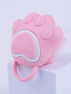 a pink hair brush sitting on top of a white block