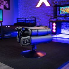 a gaming chair in front of two televisions and a bed with blue lights on it