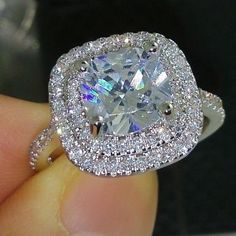 a close up of a person holding a diamond ring