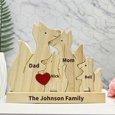 a personalized wooden figurine with the names of two dogs and a heart