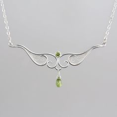 Delicate silver filigree and fresh green peridot make this necklace the special finishing touch to your outfit - whether that's a pretty blouse or a little black dress. Fancy enough for special occasions but sweet and delicate enough for a regular Tuesday at work, this piece is handcrafted with care to last for years of enjoyment. Finished with a handmade S-hook clasp and a peridot accent dangle. Materials: Sterling silver, fine silver, genuine peridot Size: pendant 2.5" across Necklace length: Delicate Green Sterling Silver Necklaces, Delicate Green Sterling Silver Necklace, Delicate Sterling Silver Necklace For May Birthstone, Delicate Green Sterling Silver Jewelry, Delicate Silver Necklace With May Birthstone, Silver Elegant Necklace With May Birthstone, Delicate Silver Necklace For May Birthstone, Elegant Lime Green Jewelry For May Birthstone, Elegant Lime Green Gemstone Necklace