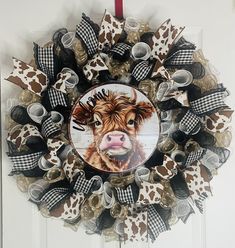 a wreath with a cow on it hanging from the front door