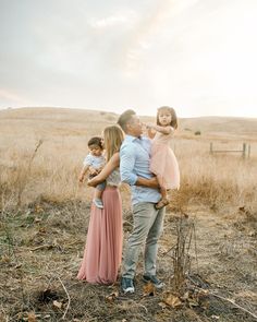 an adult and two children standing in a field