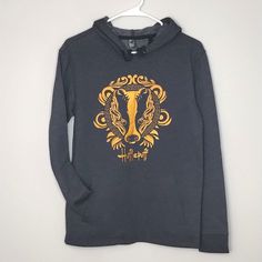 a hoodie with an image of a wolf on the front in gold and black