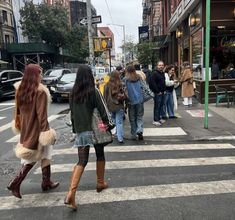 several people are crossing the street at an intersection