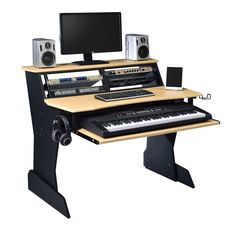 a computer desk with a keyboard, monitor and speakers on it in front of a white background