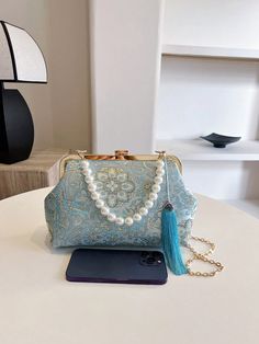 Add an elegant touch to any evening outfit with our Pearl-Adorned Blue Embroidered Handbag. The perfect accessory for parties and special occasions, this handbag features beautiful pearl embellishments and intricate embroidery. Elevate your style and make a statement with this ultimate evening accessory. Color : Blue Bag Size : Medium Pattern Type : Plants Type : Kiss Lock Bag Material : Fabric Composition : 100% Polyester Bag Height Bag Length Bag Width 17 25 8 Evening Handheld Shoulder Bag With Floral Embroidery, Handheld Floral Embroidered Shoulder Bag For Evening, Floral Embroidered Evening Bags, Handheld Floral Embroidery Shoulder Bag For Evening, Handheld Floral Embroidery Evening Shoulder Bag, Embroidered Handheld Shoulder Bag For Party, Embroidered Evening Shoulder Bag, Embroidered Shoulder Evening Bag, Handheld Embroidered Shoulder Bag For Party