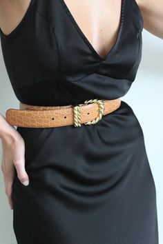 Beautiful leather belt with an embossed leather body, gold toned buckle, prong and loop. Belt buckle features a twisted appearance. Perfect styled here with our Townes Trousers, Na Nin swim as a bodysuit, & favorite vintage blazer. Holes can be added to belt as desired to fit smaller waist sizes. Made in Italy Light scratching at the belt buckle and loops, very minimal and does not affect look or wear. Gold Leather Belt For Fall, Trendy Fitted Belts For Work, Chic Leather Belt Buckles With Antique Buckle, Chic Leather Belt Buckle With Antique Detail, Chic Leather Belt Buckle With Antique Design, Chic Formal Antique Belt Buckle, Trendy Gold Belt For Fall, Trendy Gold Belts For Fall, Elegant Gold Belt For Fall