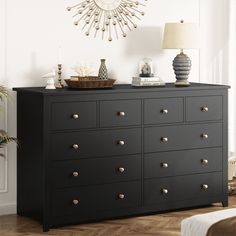 a black dresser with gold knobs in a white room