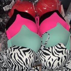 two different colored bras with zebra print on the bottom and pink, green, and black bra