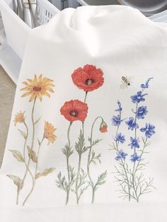 a kitchen towel with flowers on it next to a washer and dishwasher