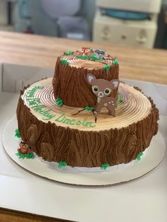 there is a cake that has been made to look like a tree stump with a deer on it