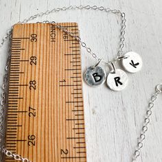 Sterling silver keepsake Initial necklace. Small circle charms are textured and stamped with the letters that mean the most to your heart. Add your initials in the order notes box at checkout. Solid sterling silver charms 1/4 wideSterling silver cable chain. Adjustable Sterling Silver Initials Name Necklace, Small Personalized Sterling Silver Necklace, Personalized Sterling Silver Initial Necklace, Everyday Silver Name Necklace With Initials, Personalized Silver Charm Necklaces With Initials, Sterling Silver Charm Name Necklace For Birthday, Personalized Adjustable Sterling Silver Initial Necklace, Stamped Round Disc Charm Necklace For Gifts, Engraved Silver Round Disc Charm Necklaces